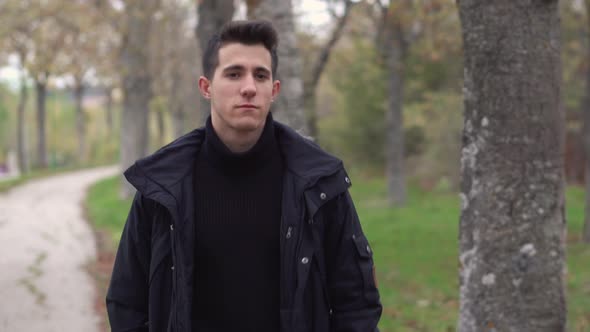  A Young Man Walks Through the Autumn Park. alt