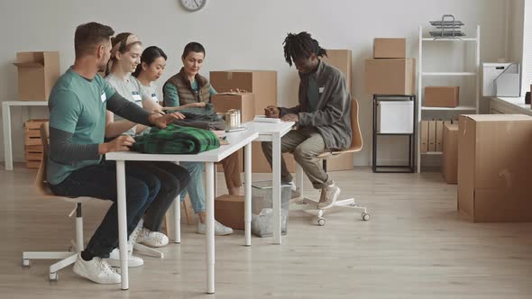 Diverse Volunteer Team Chatting at Workplace alt