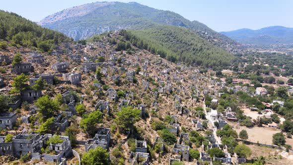 Drone flight close-up over the ruins of an ancient fortress located in the green mountain hills of T alt