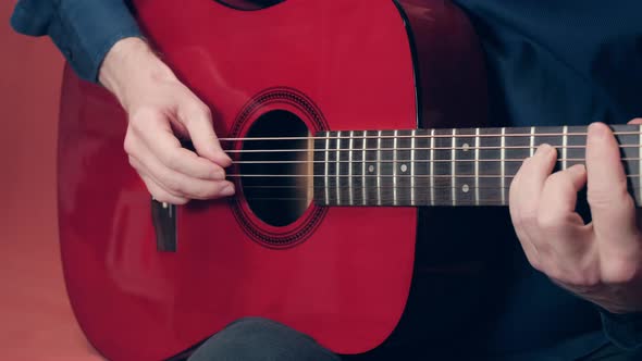 Man Plays an Acoustic Guitar with His Fingers Moving Quickly