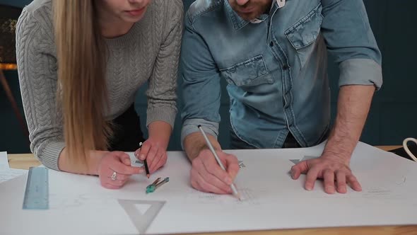 Young Woman and Man As an Architects Working with Blueprints, Laptop and House Models in the Office alt
