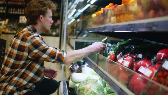 A Caucasian Man in Plaid Shirt Shopping for Fruits and Vegetables in Produce Department of a Grocery alt