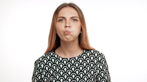 Young Beautiful Blonde Girl Showing Tongue Over White Background alt