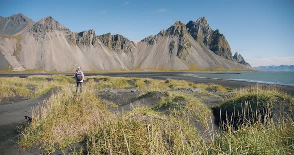Morning Scene of Female Traveler Exploring Stokksnes Cape with Vestrahorn (Batman Mountain) on