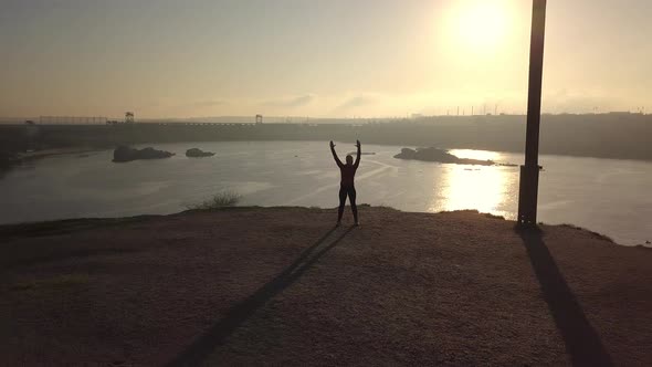 Woman Practicing Martial Arts at Riverside at Sunset