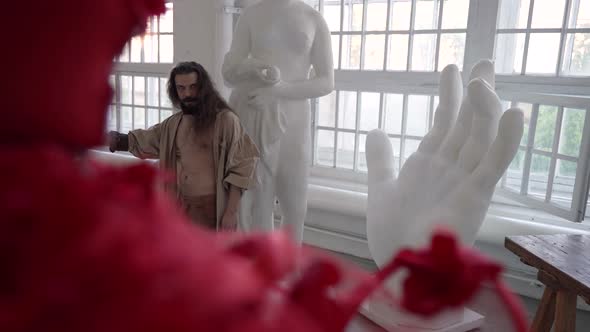 Crazy Artist is Working in His Creative Workshop Between Sculptures Drawing on Canvas alt