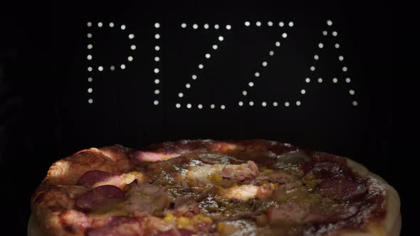 Delicious Fresh Italian Pizza  On A Black Background With The Effect Of Light Inscription Pizza