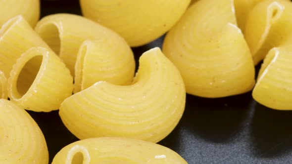 Very close shot of pipe rigate, italian macaroni, macro shot in 4k. Rotating motion, view from above alt