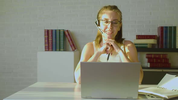 Young Adult Woman Works in Front of a Laptop Monitor in the Office  She Having Online Video Call