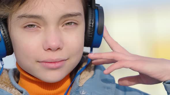 Closeup View of a Teenager Girl Listening to the Music with Closed Eyes Via Wireless Headphones and alt