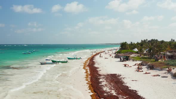 Backward Aerial Fast Motion View of Tents and Crowd of People Relaxing on a Tropical Beach on a alt