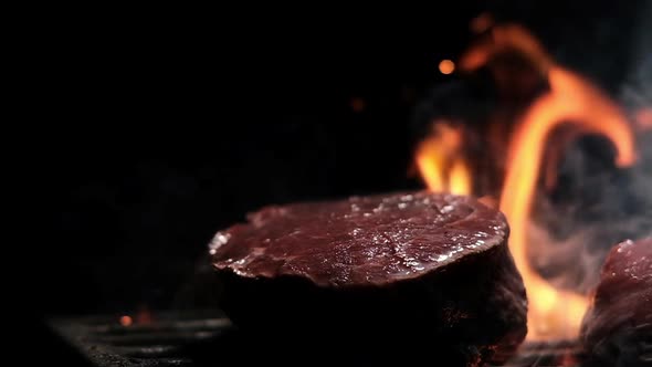 Close-up of steak fried on an open fire on grill in flame