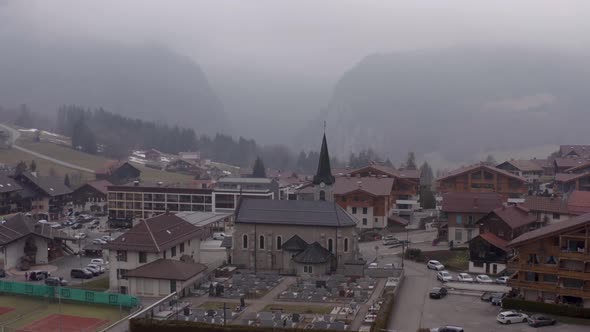 Aerial of  Saint-Jean-de-Sixt church in French Alps, scenery of recreational village with wooden bui alt