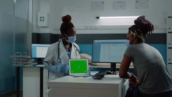 Patient and Medic Looking at Horizontal Green Screen on Tablet alt
