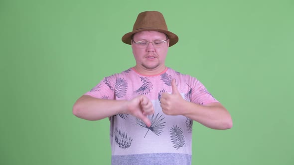 Confused Overweight Bearded Tourist Man Choosing Between Thumbs Up and Thumbs Down alt