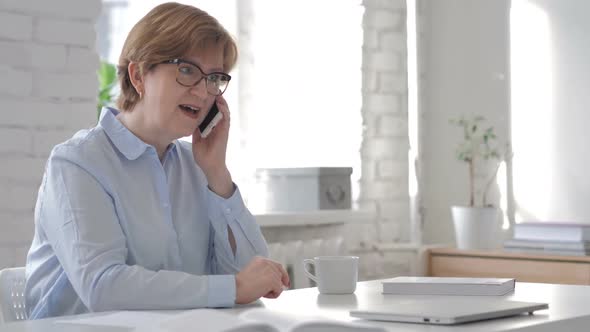 Old Woman Talking on Smartphone with Customer alt