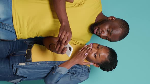 Vertical Video Man and Woman Using Internet on Smartphone Together in Front of Camera alt