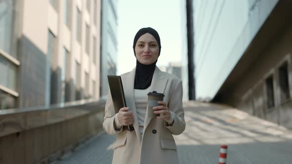 Business Lady in Hijab with Coffee and Clipboard in Hands alt