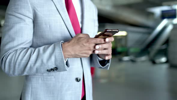 Cropped Shot of Businessman Using Smartphone alt