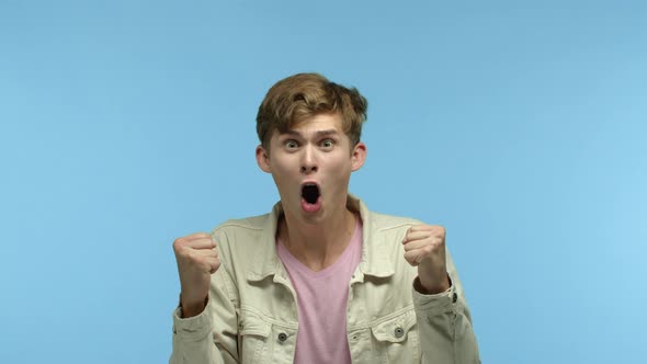 Cheerful Young Man Celebrating Victory Watching Sport Game and Winning Bet Making Fist Pump Gesture alt