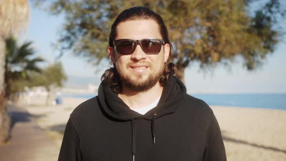 Portrait of Young Handsome Man Standing Outdoor Smiling Looking at Camera alt
