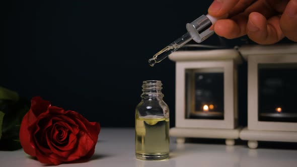 Perfumery Drops of Aroma Floral Liquids Falling From Cosmetic Pipette to Glass Bottle