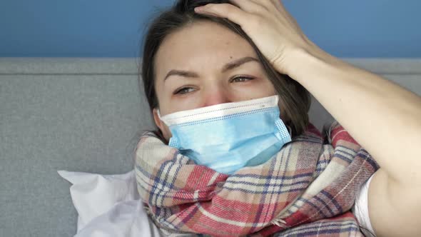 Sick Woman with a Medical Mask on the Face with Symptoms of Flu or Coronavirus Lies in Bed