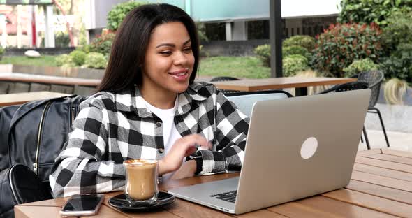 Happy young black woman make video call online.