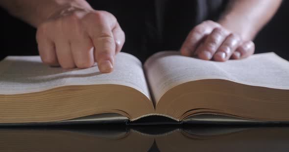 The Man Turns the Pages of the Textbook alt