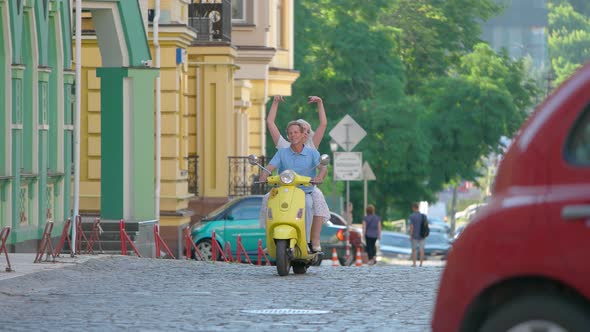 Mature Couple Riding Scooter. alt