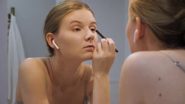 Attractive Woman Putting on Make Up with Brush Adding Mascara on Eye