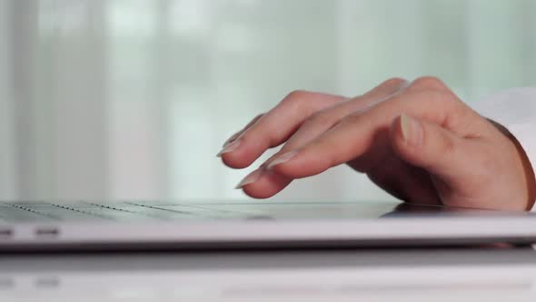 close-up female hand touching touchpad on a laptop computer