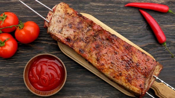 Top View of the Juicy Grilled Ribs on the Skewers Placed on the Wooden Table alt