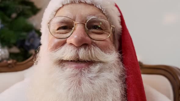 Happy Santa Claus in eyeglasses smiling looking at camera.