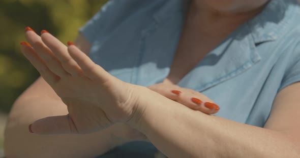 Unrecognizable Senior Woman Applying Sunscreen Outdoors. Female Caucasian Hands Rubbing Moisturizer alt