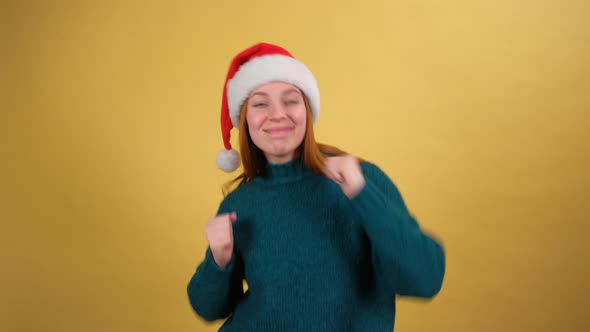 Cute Young Woman in Funny Santa Claus Hat Singing Jingle Bells and Dancing