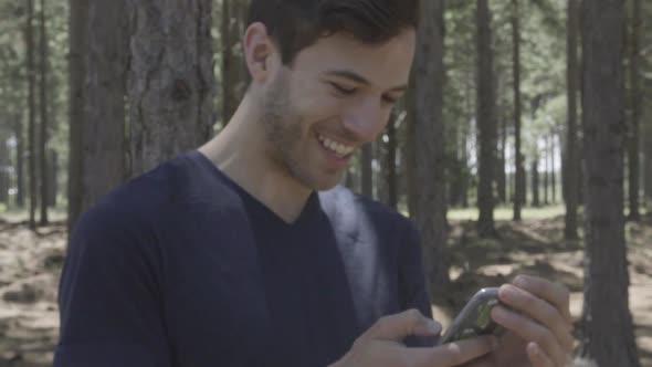 Man using smart phone in woods