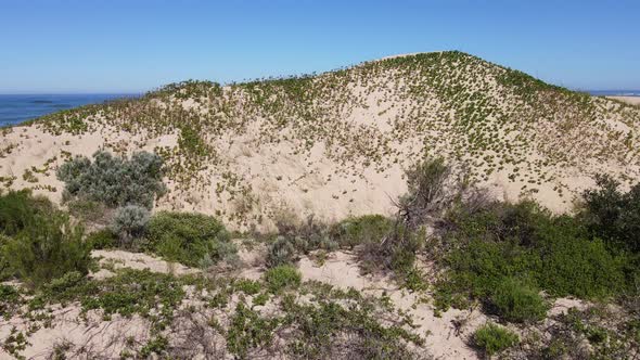 Cinematic Approach of Drone Flying Towards Sand Dune with Ocean in Horizon alt