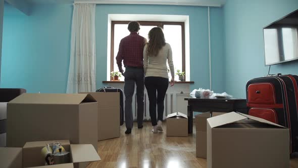 Young Couple Collects Things in a Box for Moving To a New Apartment