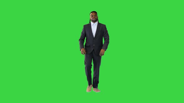 Young Black Man in Office Suit Walking Fixing Suit and Collar on a Green Screen Chroma Key