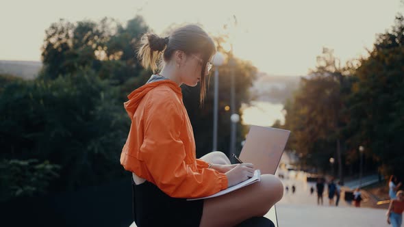 The Lonely Girl Isolated in Nature Writes Down Her Thoughts in Her Notebook alt