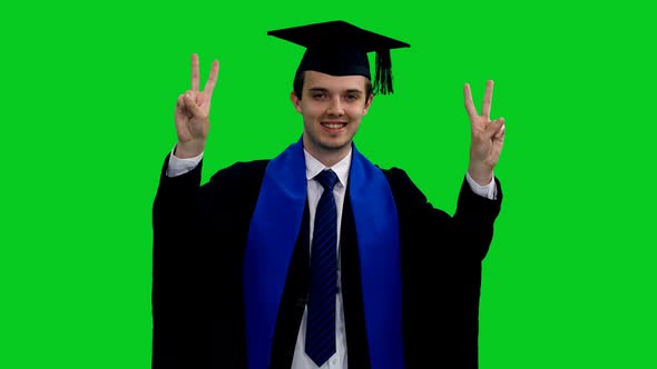 Happy Graduating Student In Gown Showing V Sign and Smiling
