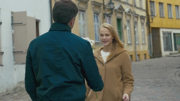 Man Giving Bunch Of Flowers To Woman alt
