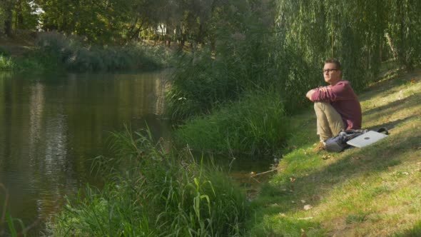 Man in Glasses is Sitting at The Slope Has Leaned alt