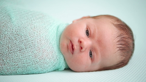 Blue-eyed Newborn Baby Lying And Looking Around alt