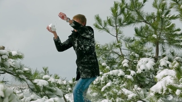 Young Couple Playing Snowball Fight In Snowy Pine