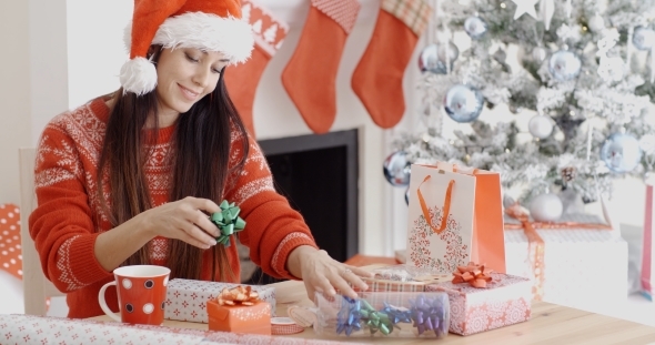Young Woman Decorating Her Christmas Gifts alt
