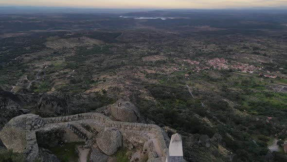 Drone shot of the surrounding areas adjacent to Monsanto Castle, highlighting the rocky boulders and alt