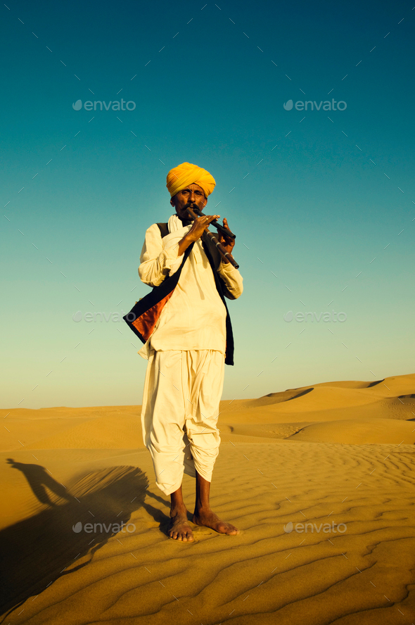 Indigenous Indian Man Playing Wind Pipe In A Desert Concept