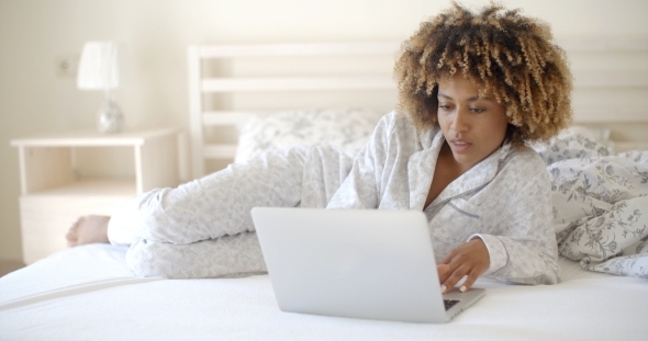 Cute Woman Using Laptop On Bed. alt